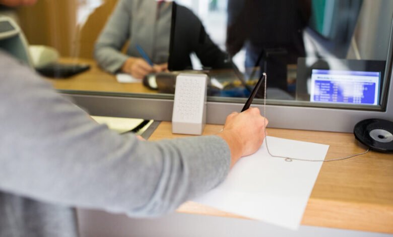 people and finance concept - customer with pen and paper writing Atención al público en una sucursal bancaria
