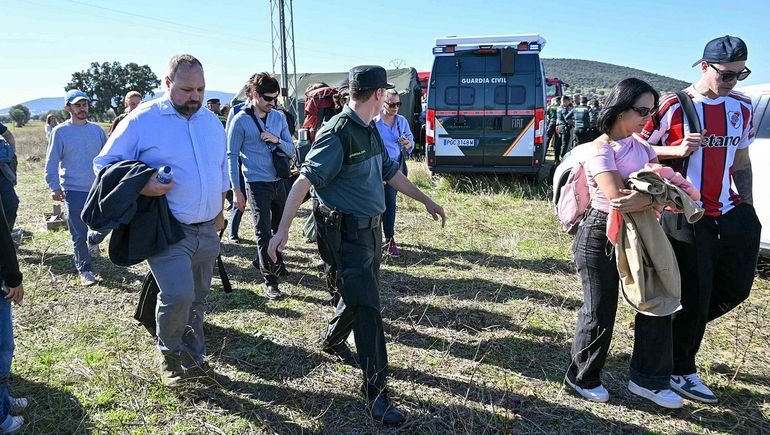 Pasajeros abandonan la zona del accidente acompañados por un agente de la Guardia Civil