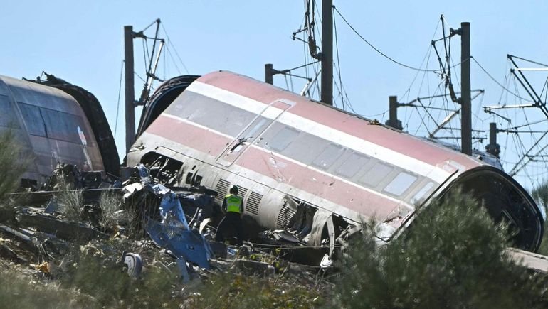 Vagón descarrilado y un integrante del operativo de emergencia junto a las vías